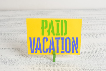Text sign showing Paid Vacation. Business photo showcasing Sabbatical Weekend Off Holiday Time Off Benefits Green clothespin white wood background colored paper reminder office supply