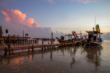 Fototapeta na wymiar Panoramic wallpaper of the morning light scenery by the sea, with small fishing boats of the villagers landing, with blurred waves of sea, a beautiful way of life by the river community