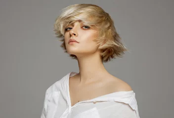 Schilderijen op glas Portrait of beautiful blonde woman in white shirt and fashionable hairstyle © kiuikson