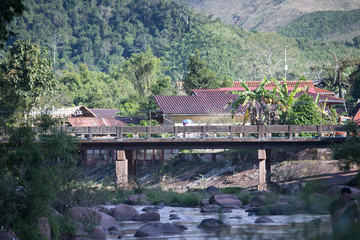 Fototapeta premium the white bridge to cross the river between the mountain