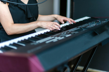 Black and white keys of the electronic piano and the skilled hands of the pianist can make magical music together.