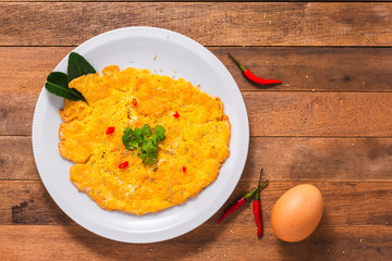 omelet with vegetables on wooden table, top view
