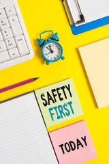 Conceptual hand writing showing Safety First. Concept meaning used to say that the most important thing is to be safe Crumpled white paper on table clock mobile and pc keyboard