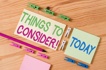 Handwriting text Things To Consider. Conceptual photo think about something carefully in order to make decision Colored clothespin papers empty reminder wooden floor background office