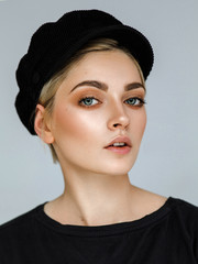 Beauty portrait of fashion young model with short hair and black cap