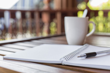 Selective focus of Pen, notebook , coffee cup on the wooden table and copy space