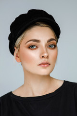 Beauty portrait of fashion young model with short hair and black cap