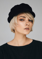 Portrait of fashion blonde woman with short hair wear cap