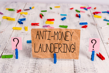 Text sign showing Anti Money Laundering. Business photo text regulations stop generating income through illegal actions Scribbled and crumbling sheet with paper clips placed on the wooden table