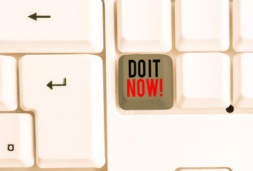 Text sign showing Do It Now. Business photo text not hesitate and start working or doing stuff right away White pc keyboard with empty note paper above white background key copy space