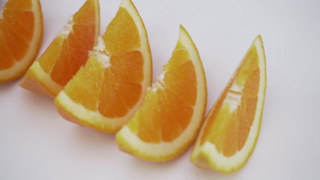 moving shot of orange slices/wedges on white isolated background, healthy food choices. 
great video for orange juice commercials