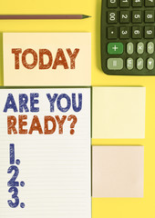 Writing note showing Are You Ready Question. Business concept for used telling someone start something when feel prepared Colored empty papers with copy space on the yellow background table