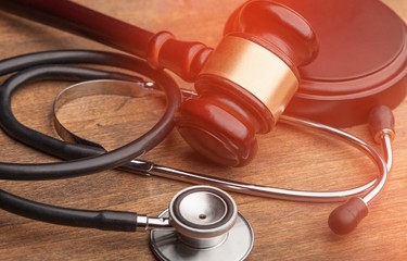 Gavel and stethoscope on wooden background