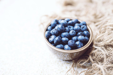 Fototapeta na wymiar Fresh ripe blueberries in a bowl, vintage look 