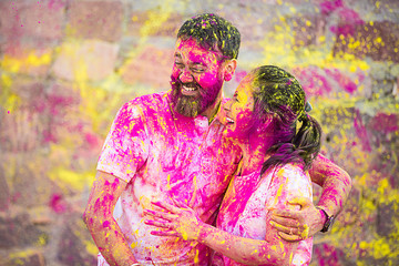 Happy  indian couple celebrating holi festival outdoor painted with colors. 
