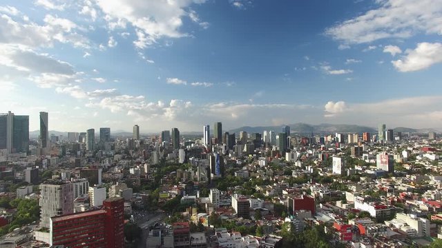 Aerial panoramic view of Paseo de la Reforma and its skyline on a clear day with blue sky. Drone flying sideways.