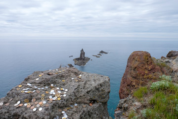 coin japan yen on A lot of Japanese money coin put on the big stone in front strange shape stones on the sea seascape cape turquoise sea with b rocks.Cape Kamui , sea view in Shakotan, Hokkaido, Japan