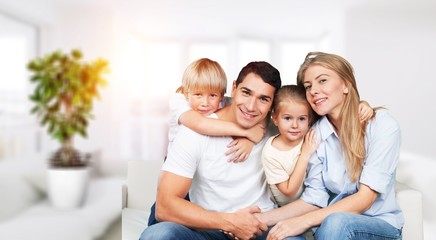 Young family at home smiling at camera