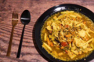 spicy vegetable soup wth vegan mince and grated vegan cheese