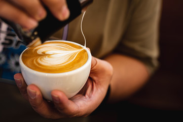 Close up barista pour milk foam made latte art.  Coffee art.
