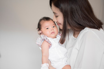 Beautiful woman holding a newborn baby in her arms