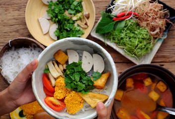 woman hand prepare homemade vegan rieu noodle soup or vegetarian crab paste vermicelli soup
