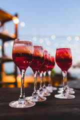 Set of red cocktails on the bar counter. Night club, evening party. Lights bokeh on background