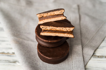Alfajor with dulce de leche sweet pastry cake, a traditional Argentine dessert with chocolate and caramel