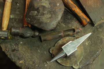 traditional worn and well used fine silversmiths tools on a craftsmans work bench in a work shop, Northern Thailand