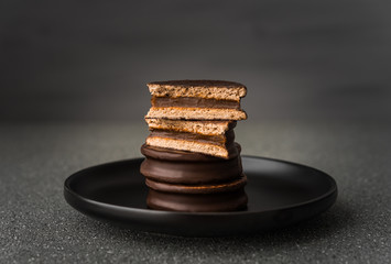 Alfajor with dulce de leche sweet pastry cake, a traditional Argentine dessert with chocolate and...