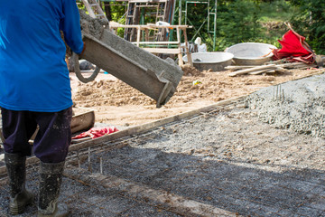 Construction workers pouring wet concrete for cement floors Concepts of labor and construction