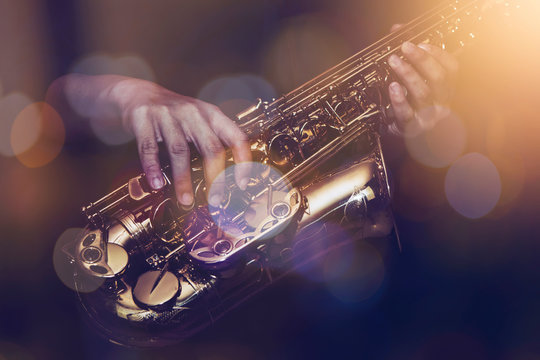 close up of saxophone player plays saxophone  with music concert light and Bokeh on stage