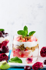 vertical image of healthy vegan berry dessert with ricotta cheese, granola and strawberry, cherry close - up with copy space from the top