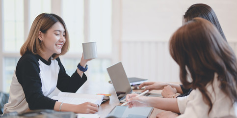 Cheerful start up team discussing the plan together in comfortable room