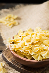 Obraz na płótnie Canvas Farfalle pasta in a wooden bowl on a wooden table. Italian cuisine