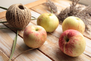 Apples, rope, dry grass on wooden background