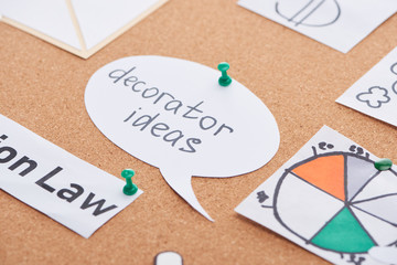 paper cards with diagram and decorator ideas inscription pinned on cork office board