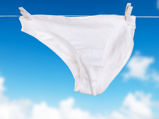 White underwear woman dry on rope over blue sky white cloud background
