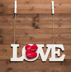 White love text hang with rope and clothespin on wooden background
