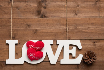 White love text hang with rope  and pine cone  on wooden background