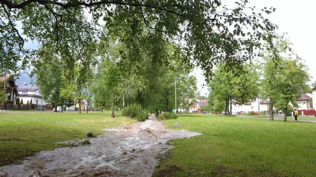 Flooded water stream running through a park after heavy rainfall