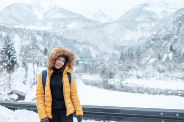 Fototapeta na wymiar Woman travel in Japan., Winter portrait of young Asian,Beautiful woman in snow. Snowing winter beauty fashion concept at Japan.Woman travel in shirakawago,Japan