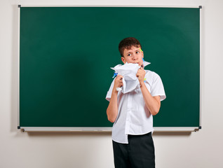 Portrait of funny pupil. School boy very emotional, having fun and very happy, blackboard...