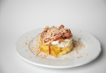 Spanish tapa, potato, fried egg, bacon and foie
