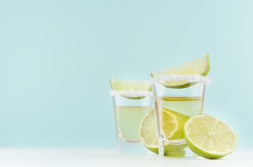 Cooking traditional mexican alcohol drink - tequila with salt rim, piece lime in shot glass on...