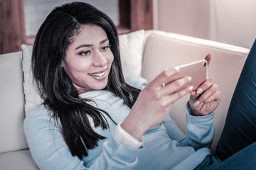 Joyful young woman watching video content on her phone