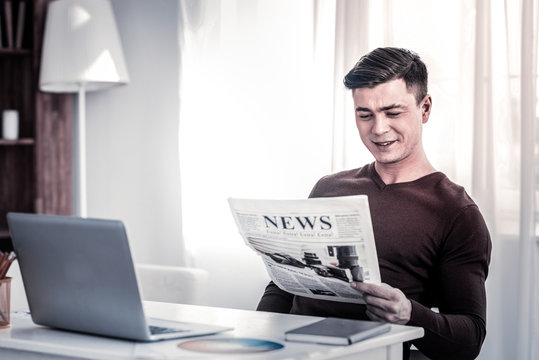 Smiling man with stylish haircut being amused by information