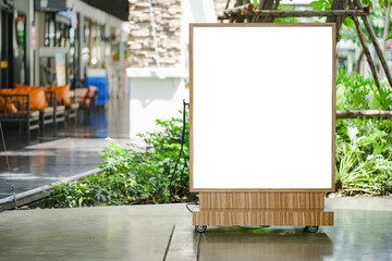Blank white outdoor advertising  board with wooden frame on concrete, mock up template included clipping path
