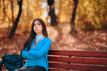 Sad Alone Woman Waiting on a Bench in a Park