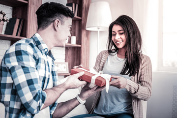 Joyful couple unpacking their presents for anniversary